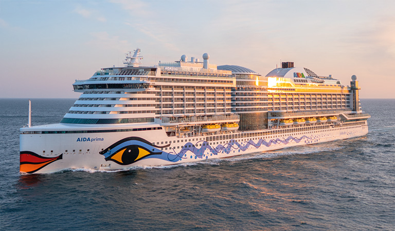 Ein großes weißes Kreuzfahrtschiff mit buntem Augenmuster fährt auf dem Meer