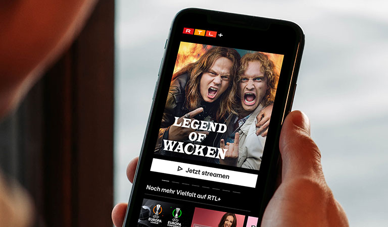 Zwei langhaarige Männer mit wilden Gesichtsausdrücken und dunkler Kleidung auf einem Handybildschirm