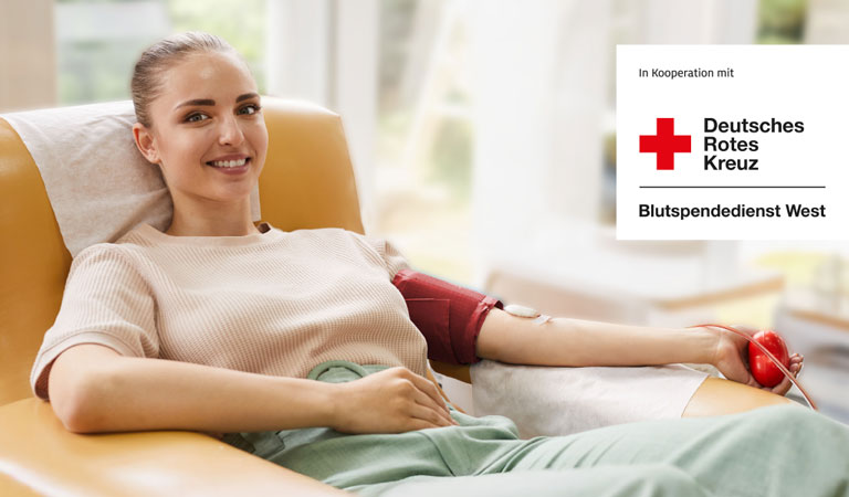 Junge Frau lächelnd beim Blutspenden, beige Kleidung, entspannte Atmosphäre