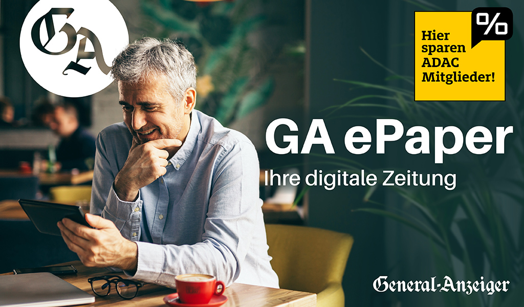 Ein lächelnder älterer Mann liest ein Tablet in einem Café.