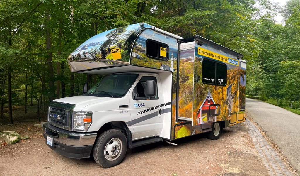 Bunte Häuser am Hang mit einer großen Kirche und blauem Himmel im Hintergrund