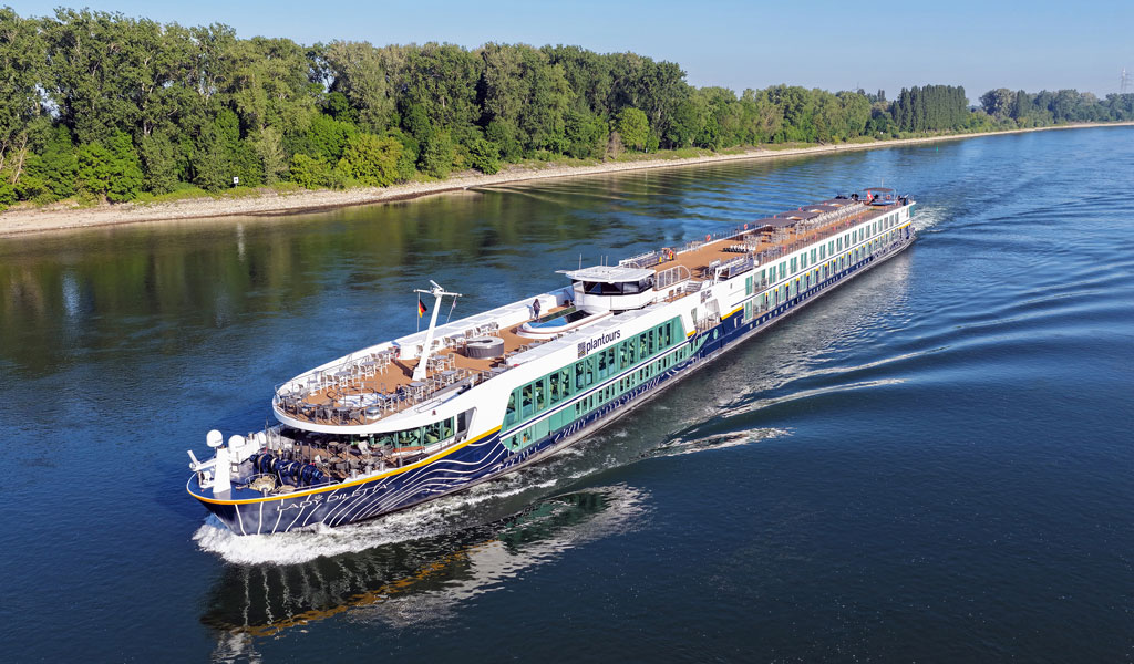 Bunte Häuser am Hang mit einer großen Kirche und blauem Himmel im Hintergrund
