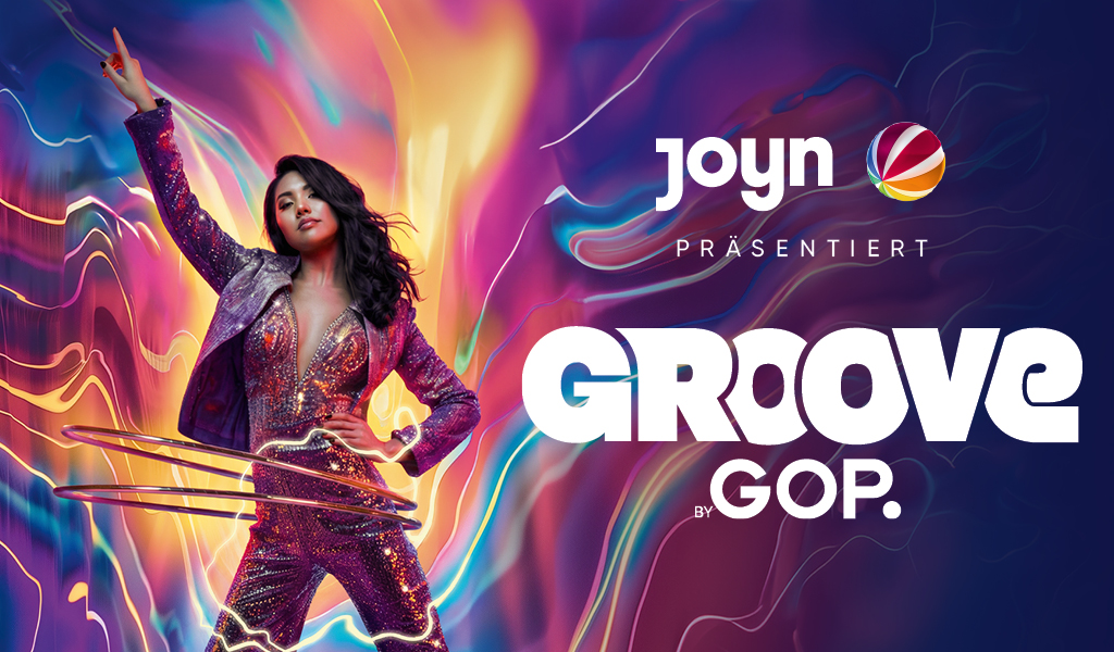 Frau mit selbstbewusstem Ausdruck in glitzerndem lila Anzug vor buntem Hintergrund