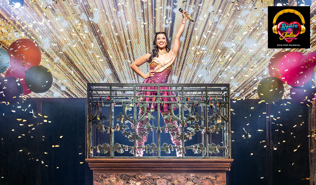 Frau in festlichem Kleid strahlt lächelnd auf einer Bühne mit goldenen Lichteffekten