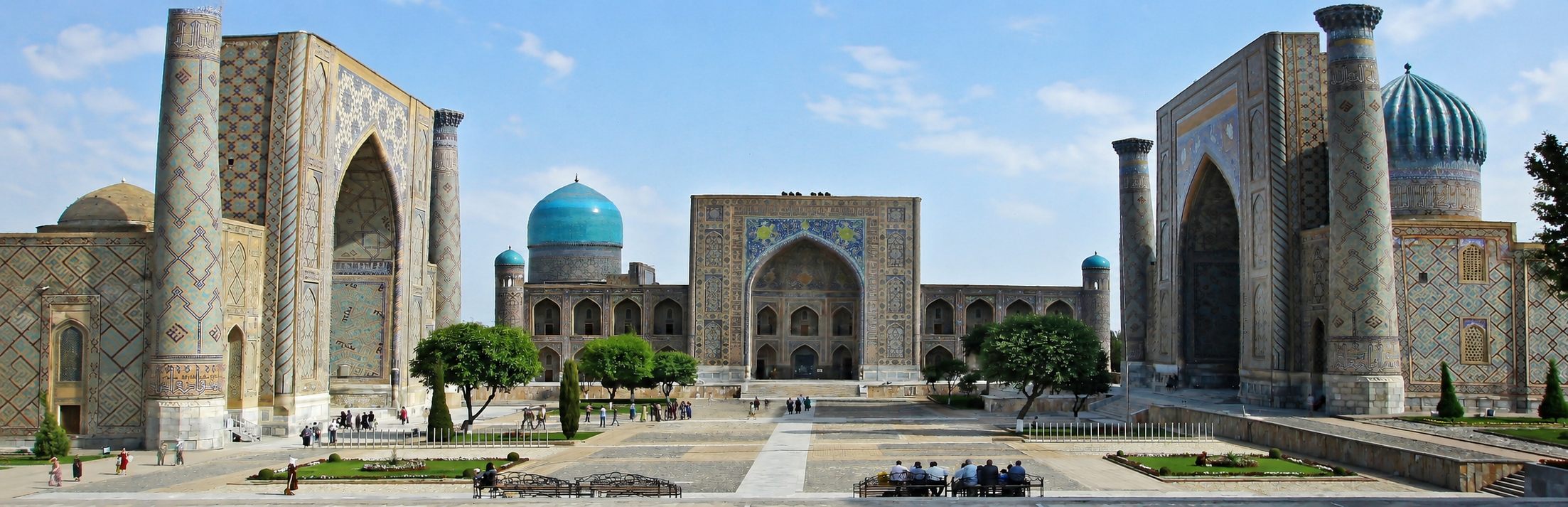 Historischer Platz mit prächtigen Mosaikgebäuden und türkisfarbenen Kuppeln im Sonnenschein