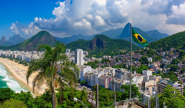 Ein Überblick über eine brasilianische Stadt mit Strand, grüner Umgebung und Flagge
