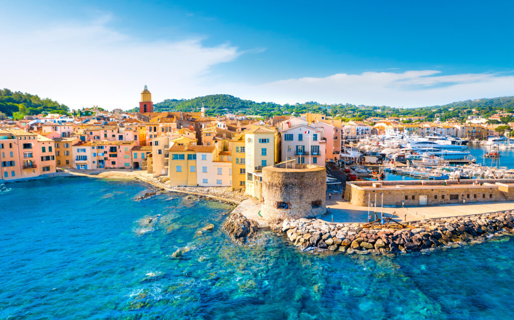 Die farbenfrohen Gebäude am Hafen von Saint Tropez strahlen in der Sonne am blauen Meer
