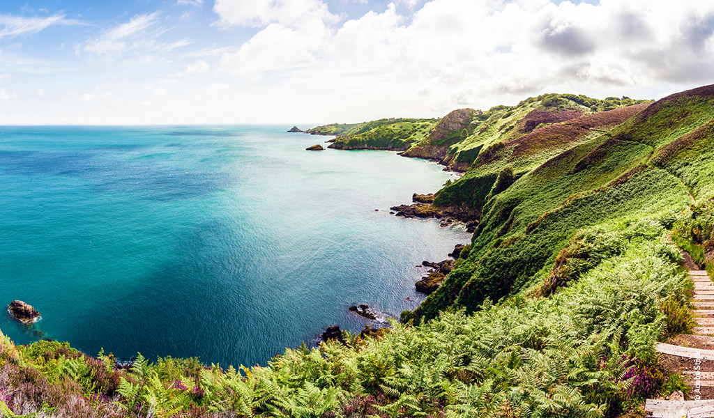 Ein ruhiger Blick über eine grüne Klippenlandschaft am türkisblauen Meer