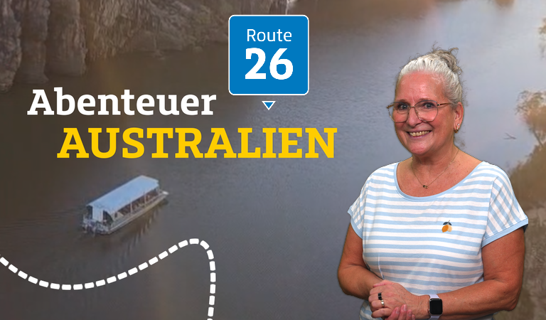 Eine ältere, freundlich lächelnde Frau mit Brille steht vor einem Fluss in Australien